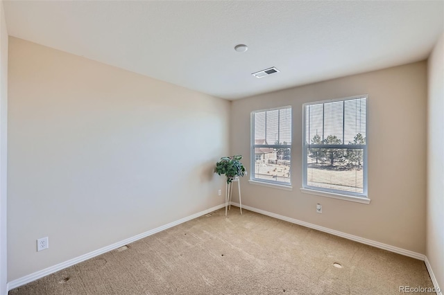 spare room with visible vents, baseboards, and carpet flooring