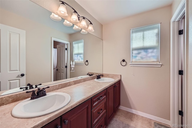 bathroom featuring a sink, baseboards, and plenty of natural light