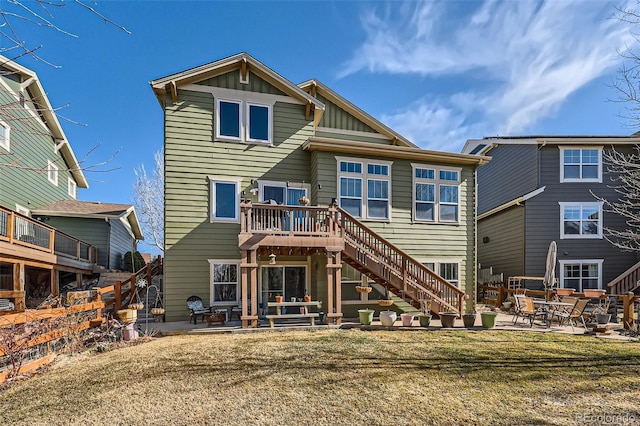 rear view of property with stairs, a yard, a patio area, and board and batten siding