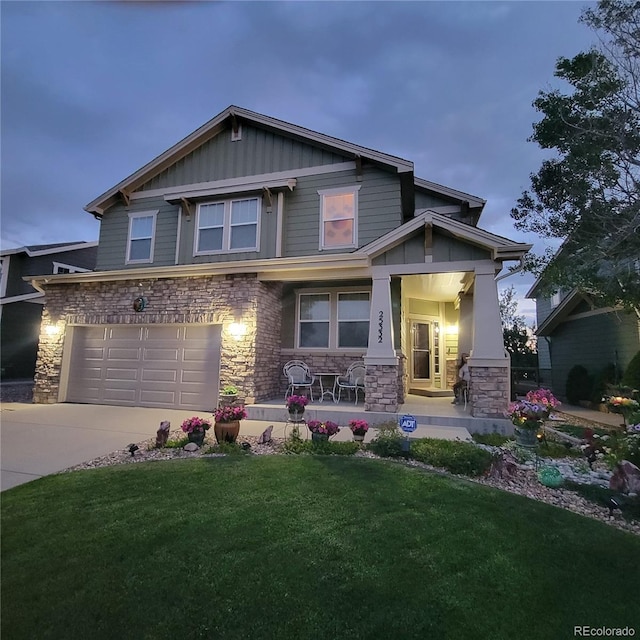 craftsman inspired home featuring board and batten siding, concrete driveway, a front yard, stone siding, and an attached garage