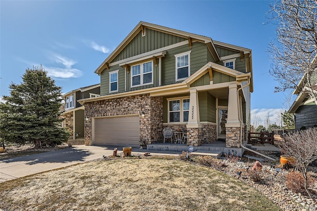 craftsman inspired home with stone siding, a porch, board and batten siding, concrete driveway, and an attached garage