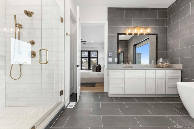 bathroom featuring tile walls, vanity, tile patterned floors, and separate shower and tub