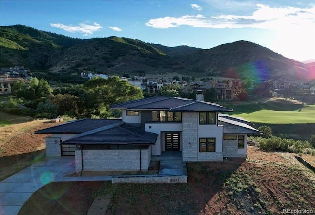 view of front of home featuring driveway, a chimney, and a mountain view