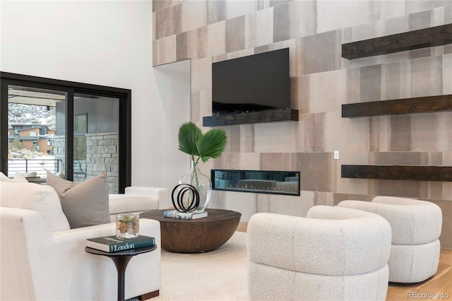 living area with wood finished floors and a tile fireplace