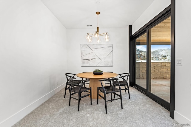 carpeted dining room featuring an inviting chandelier