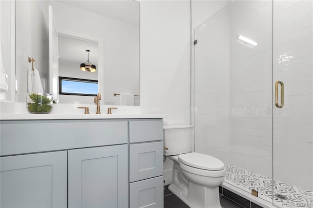 bathroom featuring vanity, an enclosed shower, and toilet