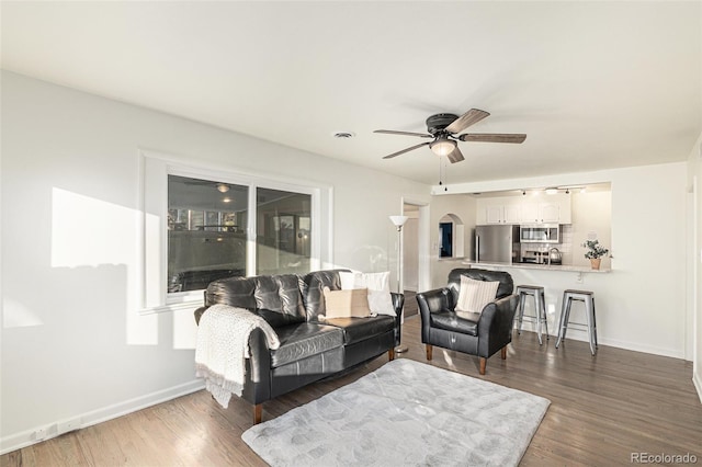 living room with dark hardwood / wood-style floors and ceiling fan