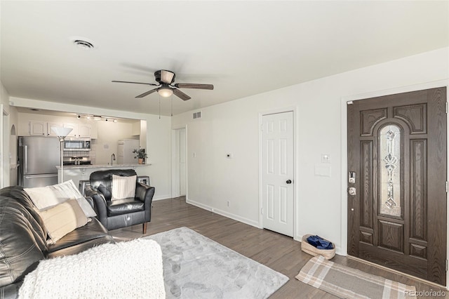 living room with wood-type flooring, ceiling fan, and sink