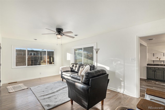 living room with ceiling fan and light hardwood / wood-style flooring