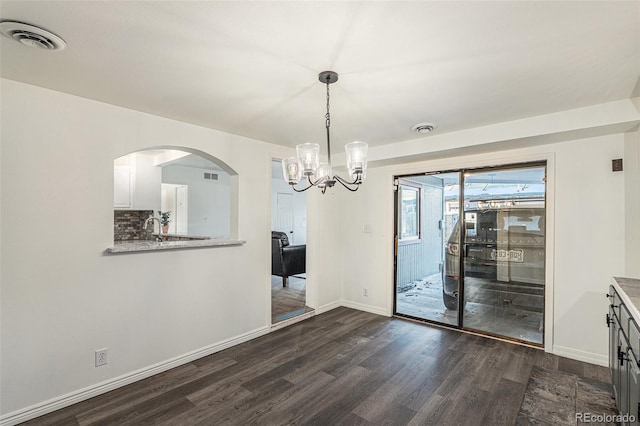 unfurnished dining area with a chandelier and dark wood-type flooring