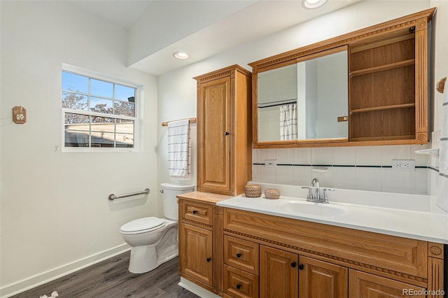 bathroom with vanity, toilet, walk in shower, tasteful backsplash, and wood-type flooring