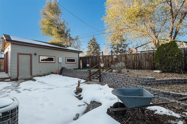 yard covered in snow with an outdoor structure and central air condition unit