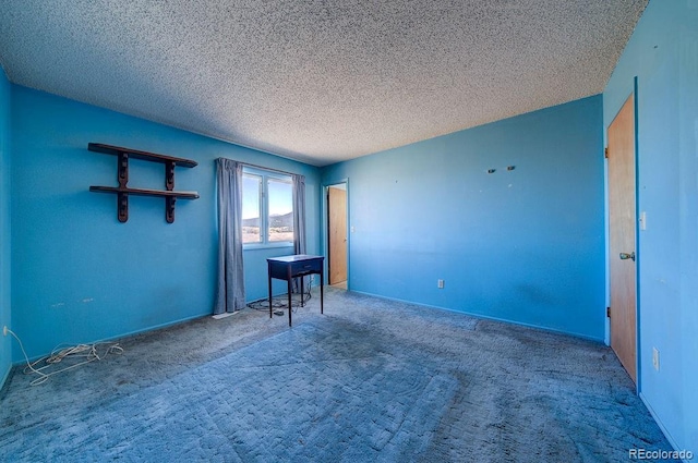 empty room featuring carpet and a textured ceiling