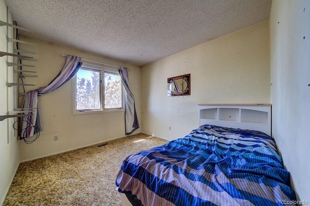 carpeted bedroom featuring a textured ceiling