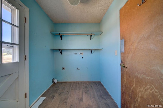 washroom with washer hookup, a textured ceiling, hardwood / wood-style floors, and electric dryer hookup