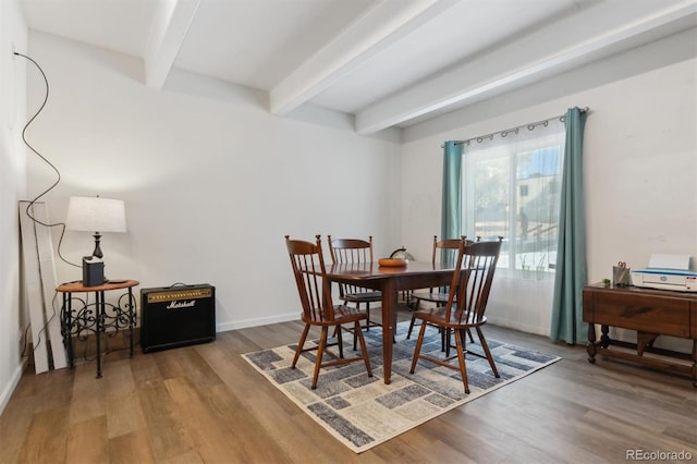 dining space with wood-type flooring and beam ceiling