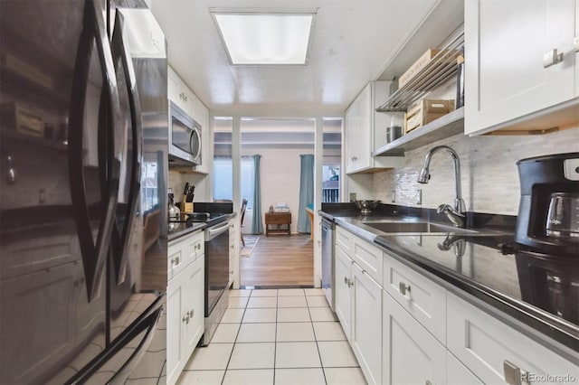 kitchen with sink, light tile patterned floors, white cabinetry, stainless steel appliances, and tasteful backsplash