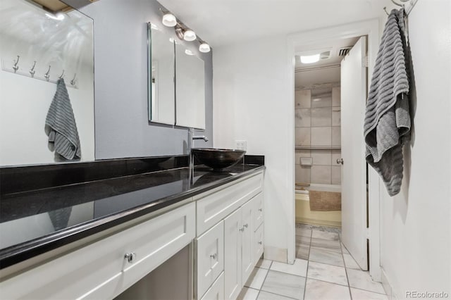 bathroom featuring tile patterned floors, vanity, and tiled shower / bath combo