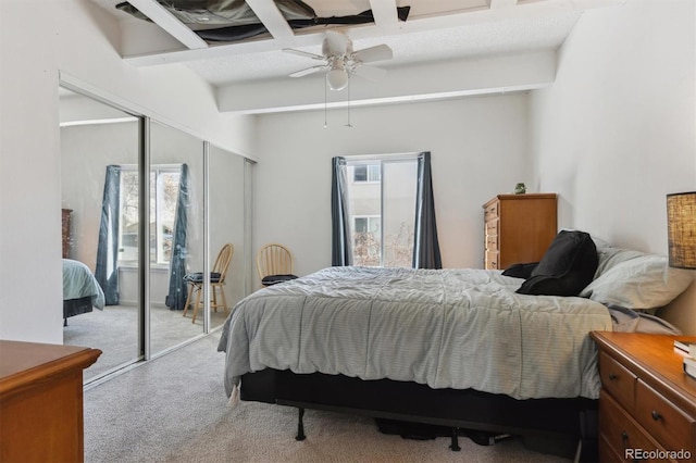 carpeted bedroom with beam ceiling and ceiling fan