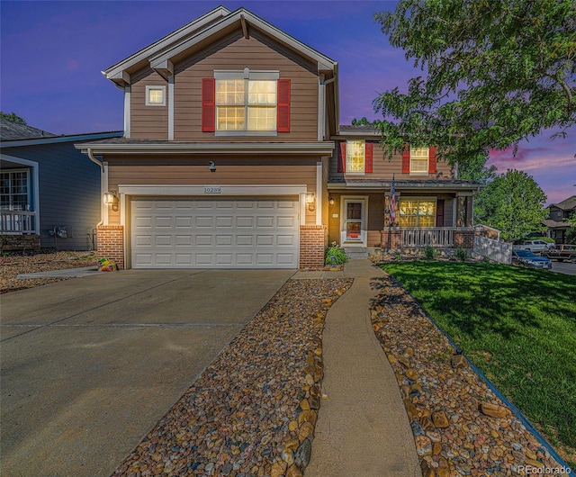 10289 Dresden St, Firestone, CO 80504 - traditional home featuring an attached garage, a porch, concrete driveway, a front lawn, and brick siding