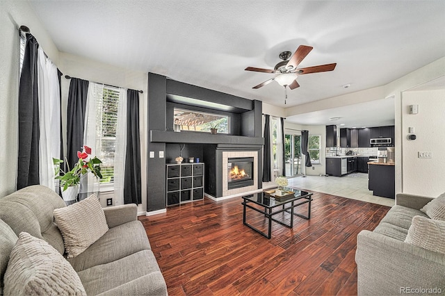10289 Dresden St, Firestone, CO 80504 - living area with a ceiling fan, plenty of natural light, light wood-style floors, and a tile fireplace