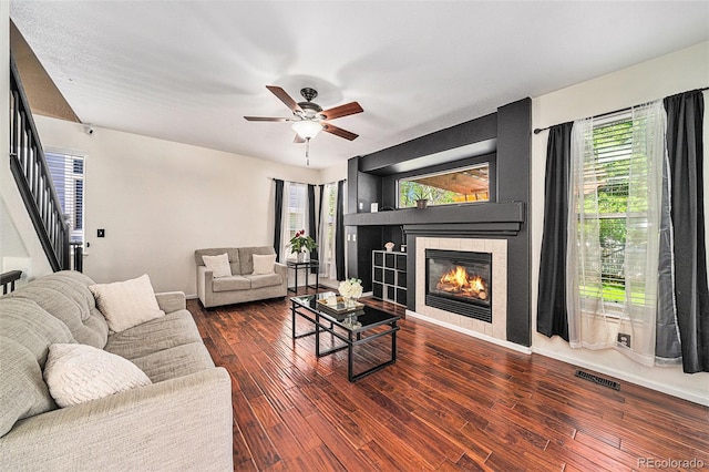 10289 Dresden St, Firestone, CO 80504 - living room featuring a tile fireplace, a ceiling fan, wood finished floors, stairway, and healthy amount of natural light