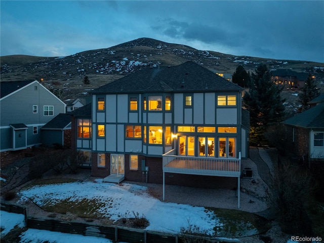 rear view of property featuring a mountain view and stucco siding