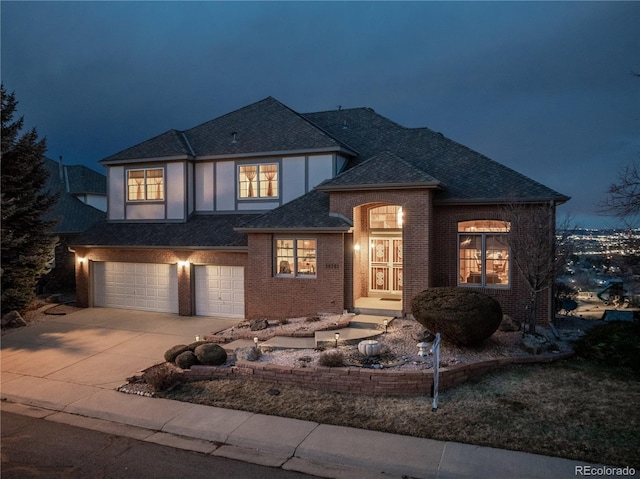 view of front of property with a shingled roof, brick siding, driveway, and an attached garage