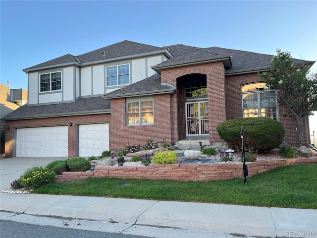 view of front of home featuring a garage, brick siding, concrete driveway, roof with shingles, and stucco siding