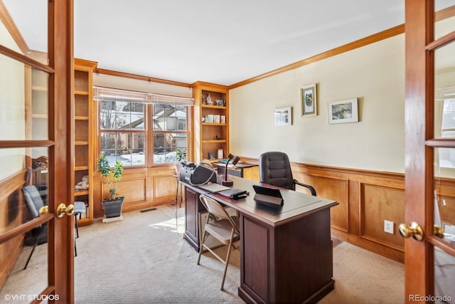 office space featuring visible vents, wainscoting, carpet, crown molding, and a decorative wall