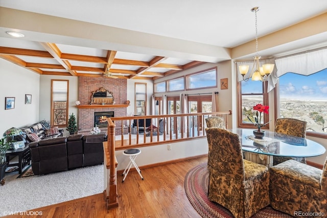 dining room featuring a fireplace, coffered ceiling, a wealth of natural light, and wood finished floors