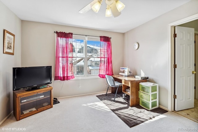 carpeted office with ceiling fan and baseboards