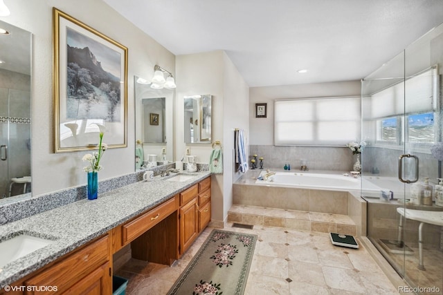 bathroom with double vanity, a garden tub, a shower stall, and a sink