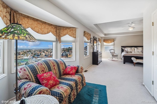 bedroom with a ceiling fan, carpet, a tray ceiling, and baseboards