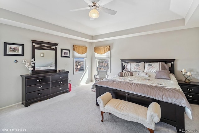 bedroom featuring carpet, a raised ceiling, and a ceiling fan