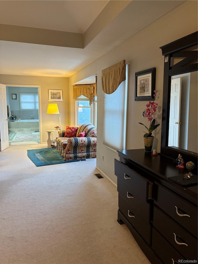 living area with baseboards, visible vents, and light colored carpet