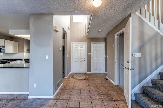 tiled entryway featuring a textured ceiling