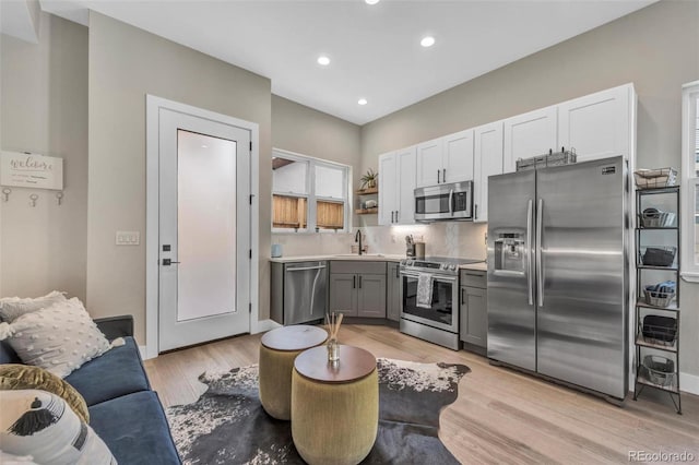 3219 W 19th Ave Unit 4, Denver, CO 80204 - kitchen with appliances with stainless steel finishes, open shelves, a sink, light wood-style floors, and recessed lighting