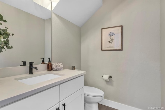 3219 W 19th Ave Unit 4, Denver, CO 80204 - half bathroom featuring vanity, toilet, lofted ceiling, wood finished floors, and baseboards