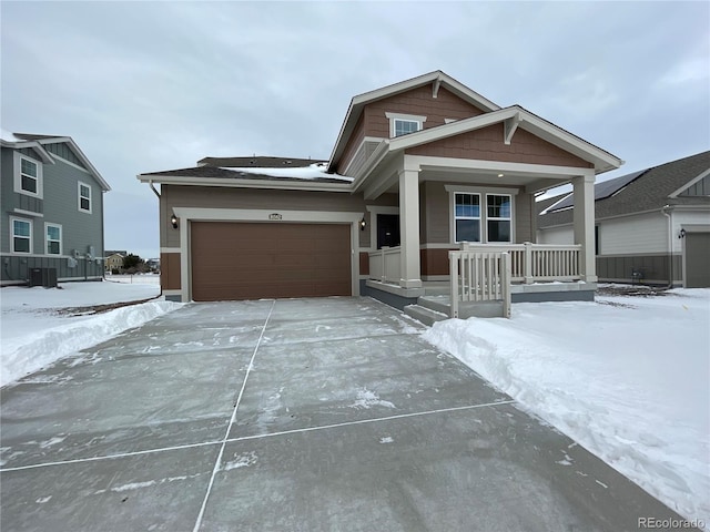 view of front of home with cooling unit, a garage, and covered porch