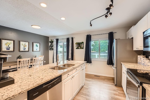 19196 E Kansas Dr, Aurora, CO 80017 - kitchen with stainless steel appliances, light wood-style flooring, plenty of natural light, light stone counters, and recessed lighting