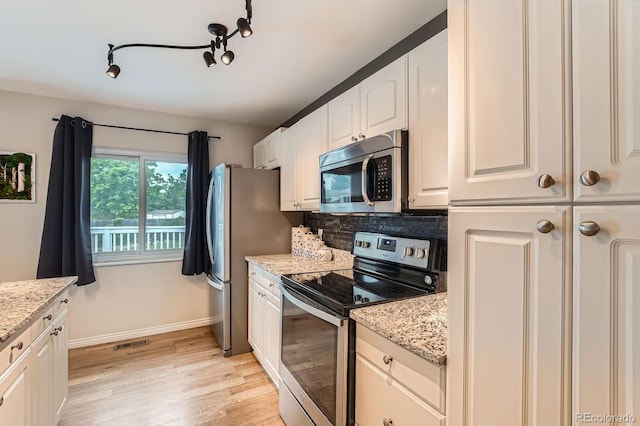 19196 E Kansas Dr, Aurora, CO 80017 - kitchen featuring stainless steel appliances, light wood finished floors, decorative backsplash, and light stone countertops