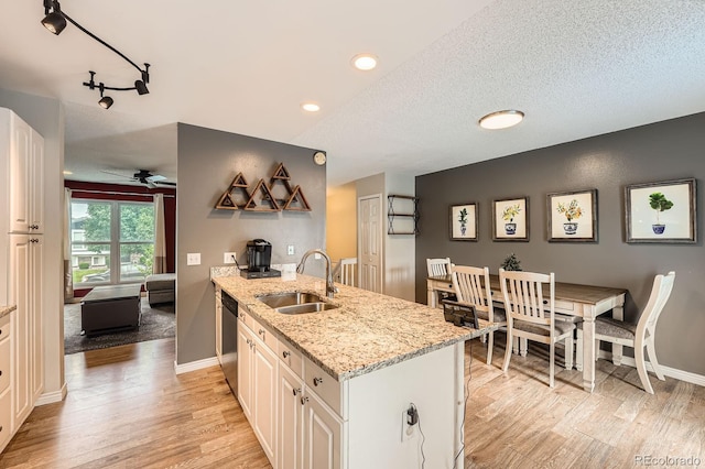 19196 E Kansas Dr, Aurora, CO 80017 - kitchen with dishwasher, light wood-style flooring, a peninsula, a ceiling fan, and a textured ceiling