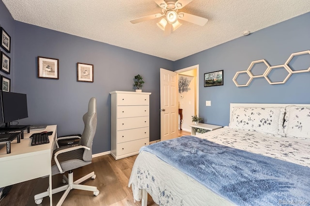 19196 E Kansas Dr, Aurora, CO 80017 - bedroom featuring wood finished floors, a textured ceiling, an office area, and a ceiling fan