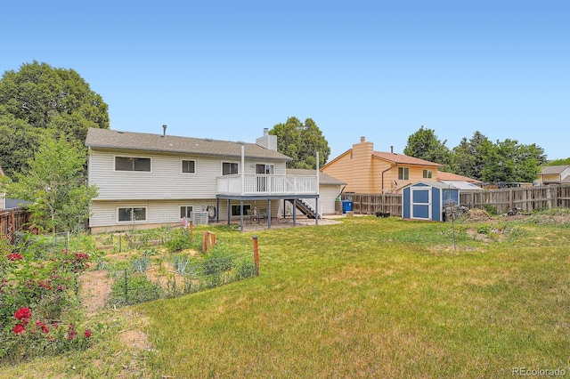 19196 E Kansas Dr, Aurora, CO 80017 - rear view of property with a shed, a wooden deck, a fenced backyard, stairs, and a chimney