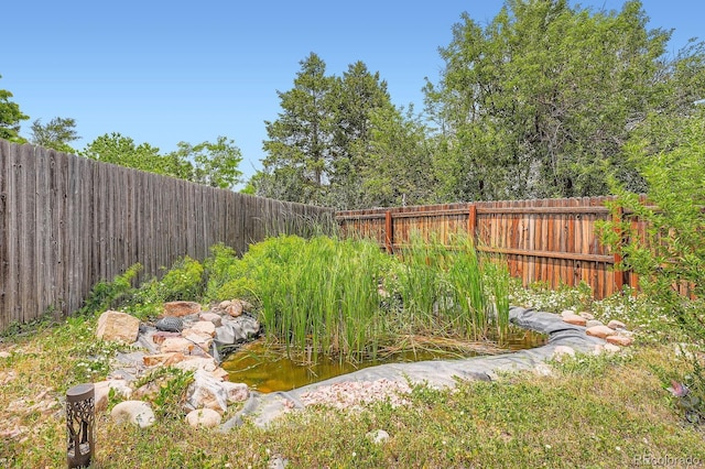 19196 E Kansas Dr, Aurora, CO 80017 - fenced backyard with a small pond