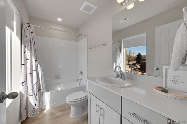 full bathroom with shower / tub combo, vanity, wood finished floors, and visible vents