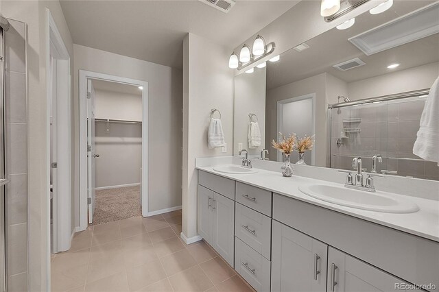 bathroom featuring baseboards, visible vents, a sink, and a stall shower