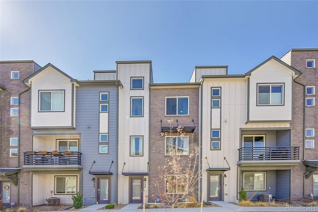 townhome / multi-family property featuring board and batten siding and cooling unit