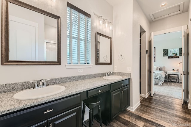16546 Umatilla Pl, Broomfield, CO 80023 - bathroom with double vanity, connected bathroom, wood finished floors, and baseboards